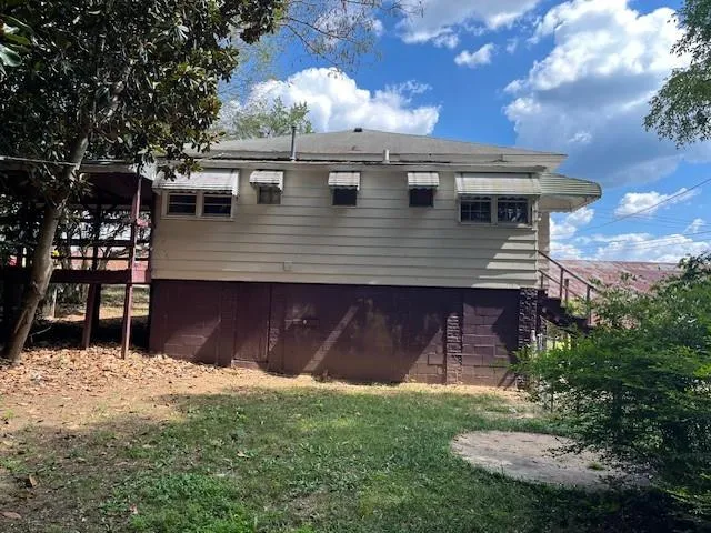 a view of a house with backyard and a tree