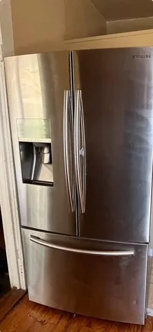 a kitchen with stainless steel appliances granite countertop a sink a stove a refrigerator a sink and dishwasher with wooden floor