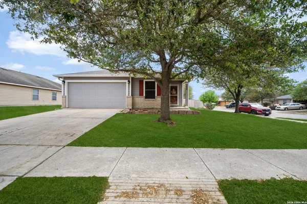 a front view of a house with a garden and trees