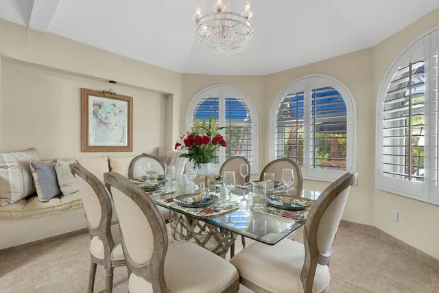 a dining room with furniture a large window and a chandelier