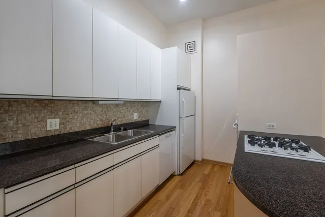 a kitchen with granite countertop white cabinets and black appliances