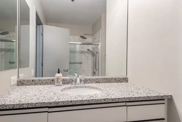 a bathroom with a granite countertop sink and a mirror