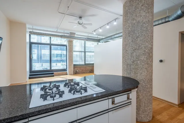 a view of kitchen island with a sink and wooden floor