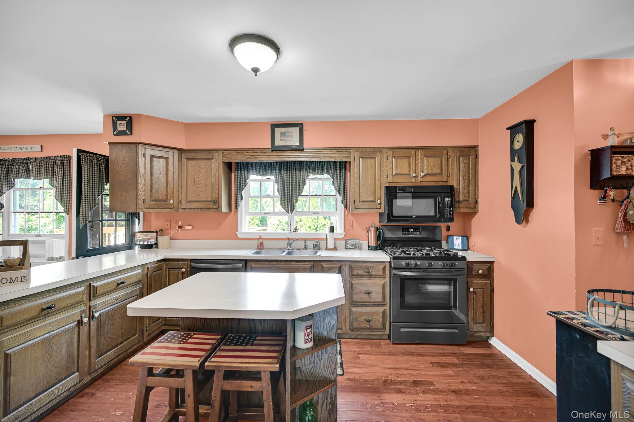 28 Brady Road Warwick, NY 10990 - Photo 15 of 50 a kitchen with a stove a sink dishwasher and a microwave oven with wooden floor