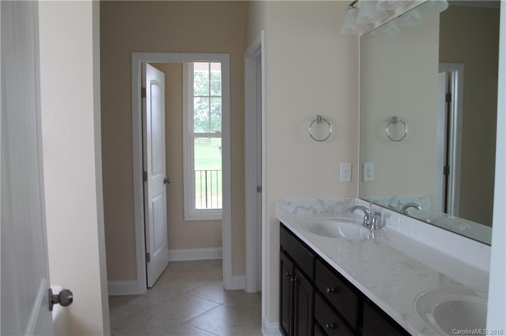 4216 Sincerity Road, Unit 1 Monroe, NC 28110 - Photo 14 of 21 a bathroom with a granite countertop sink and a mirror