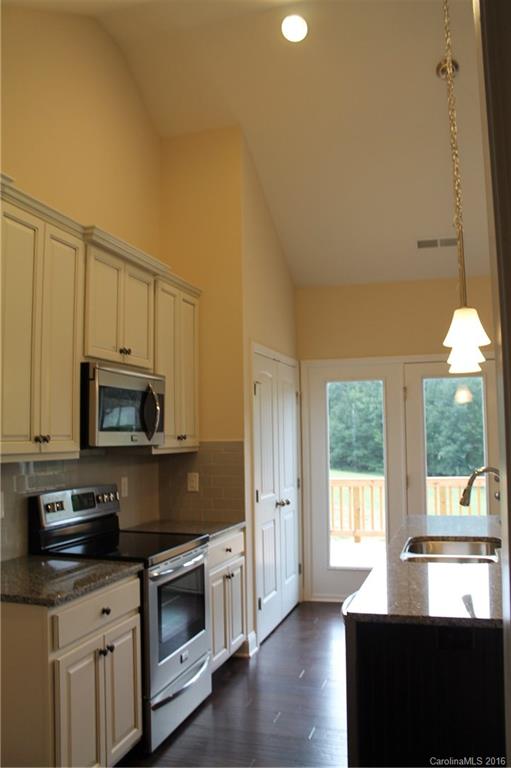 4216 Sincerity Road, Unit 1 Monroe, NC 28110 - Photo 3 of 21 a kitchen with granite countertop a stove a sink and a microwave