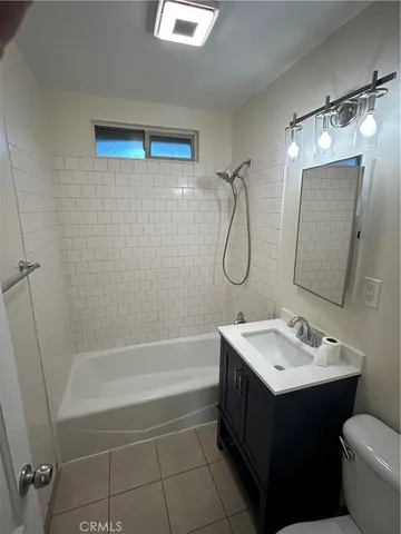 a bathroom with a sink mirror toilet and bathtub