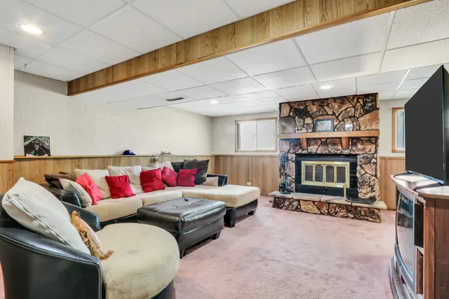 a living room with furniture a flat screen tv and a wall painting