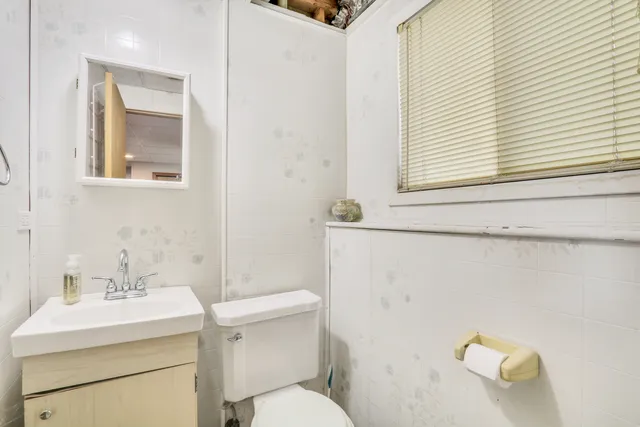 a bathroom with a sink a toilet and a mirror