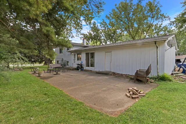 a backyard of a house with table and chairs