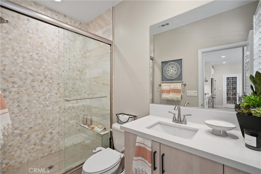 32522 Brunello Way Temecula, CA 92591 - Photo 57 of 75 a bathroom with a granite countertop sink a toilet and a mirror