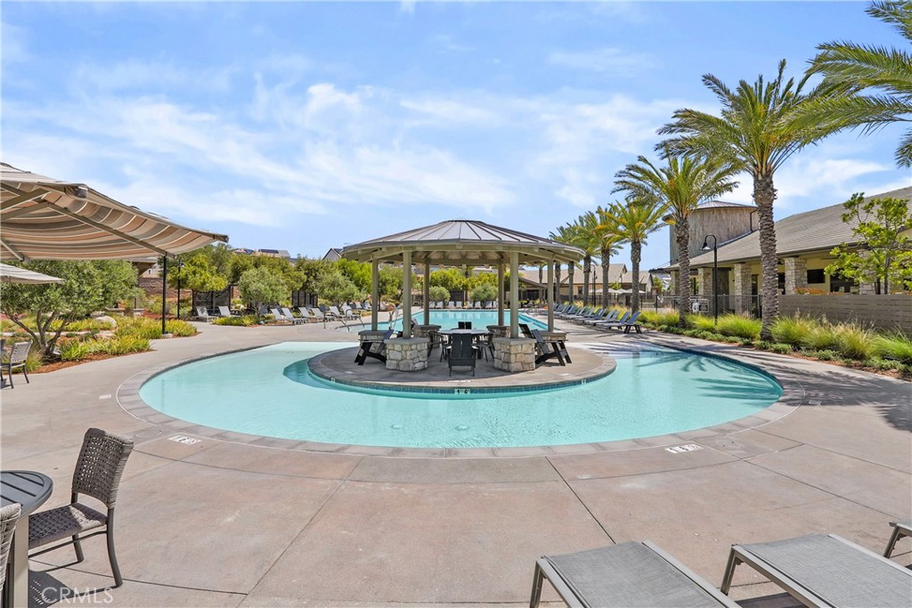 32522 Brunello Way Temecula, CA 92591 - Photo 67 of 75 a view of a swimming pool with a table and chairs