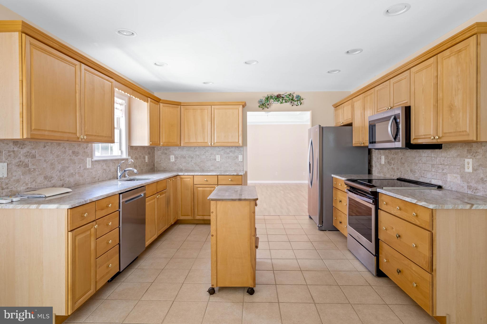 4 Alderleaf Drive Lewes, DE 19958 - Photo 12 of 43 a kitchen with stainless steel appliances granite countertop a sink counter space cabinets and a large window