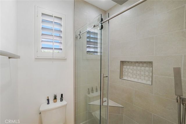 a bathroom with a granite countertop sink a toilet and a window