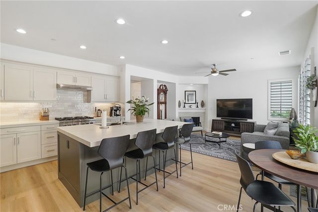a kitchen with a dining table chairs stainless steel appliances and cabinets