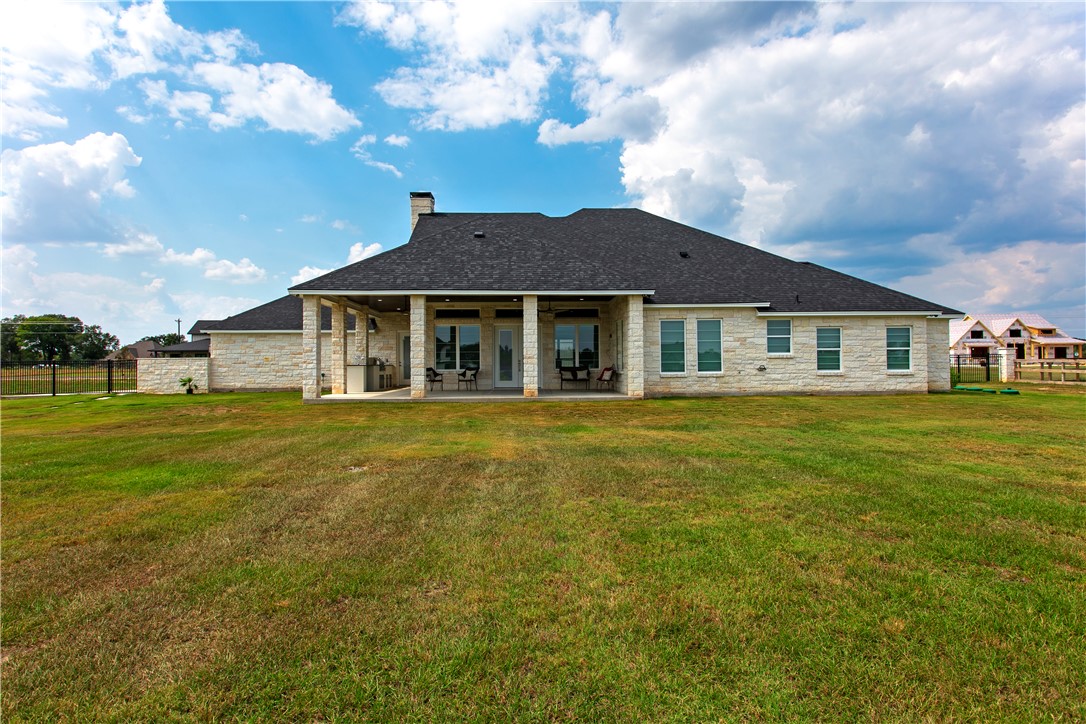 7844 Mathis Crk Drive Bryan, TX 77808 - Photo 34 of 41 Rear view of house featuring a patio, stone siding, a chimney, and a shingled roof