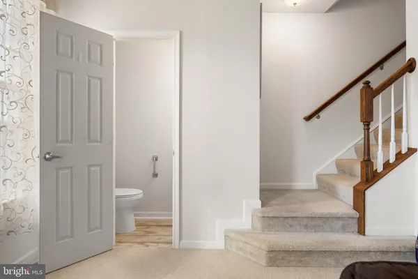 a view of a hallway with toilet & entryway