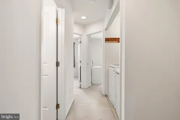 a view of a hallway with closet and a bathroom