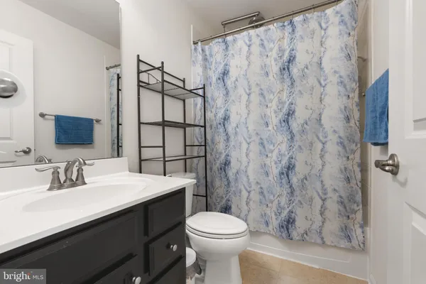 a bathroom with a sink a toilet and shower curtain