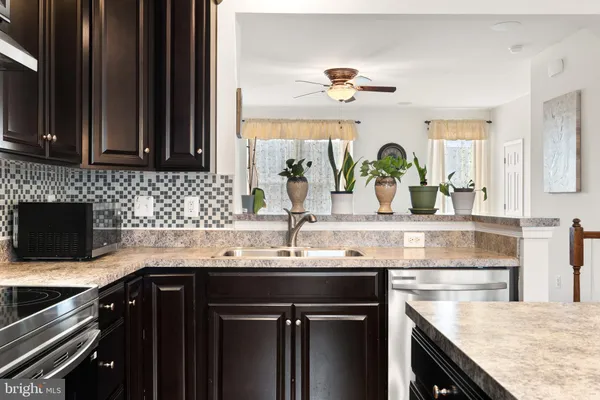 a kitchen with granite countertop a sink stainless steel appliances and cabinets