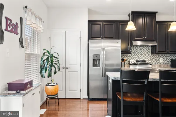 a kitchen with stainless steel appliances granite countertop a refrigerator and a stove