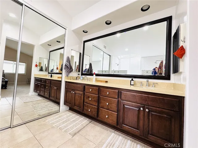 a spacious bathroom with double vanity and a large mirror