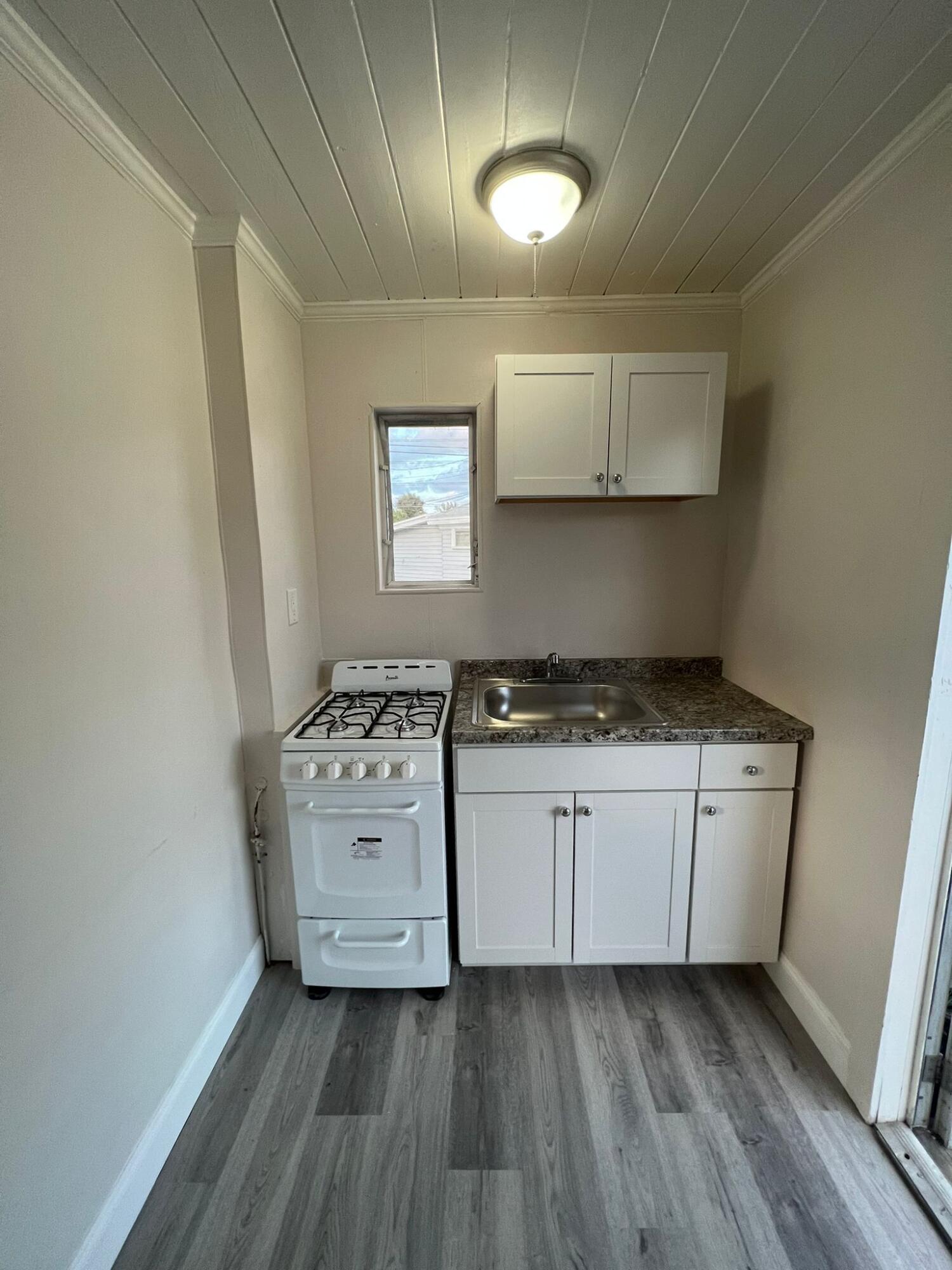 a kitchen with stove cabinets and wooden floor