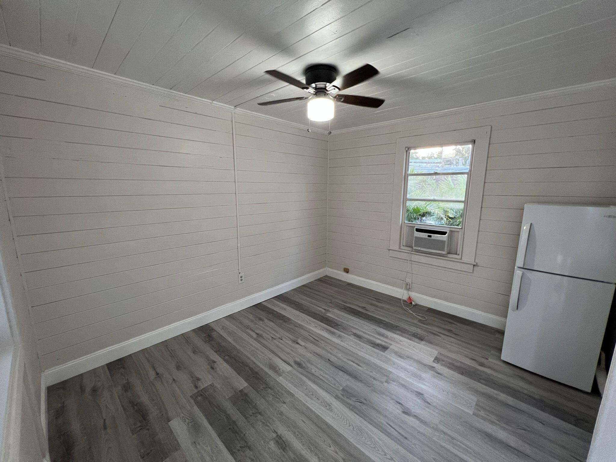 2843 Forest Hill Boulevard, Unit 7 Palm Springs, FL 33406 - Photo 2 of 8 a view of a livingroom with wooden floor and a ceiling fan