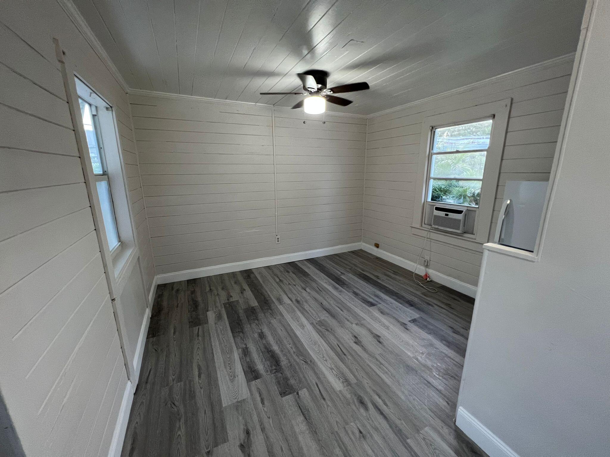 2843 Forest Hill Boulevard, Unit 7 Palm Springs, FL 33406 - Photo 3 of 8 wooden floor in an empty room with a window