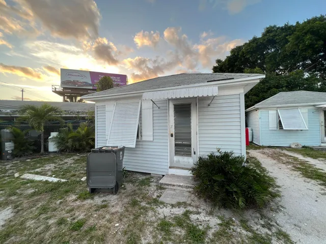 a view of backyard of house with wooden fence