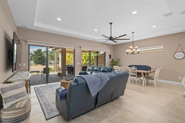 a living room with furniture a flat screen tv and a floor to ceiling window