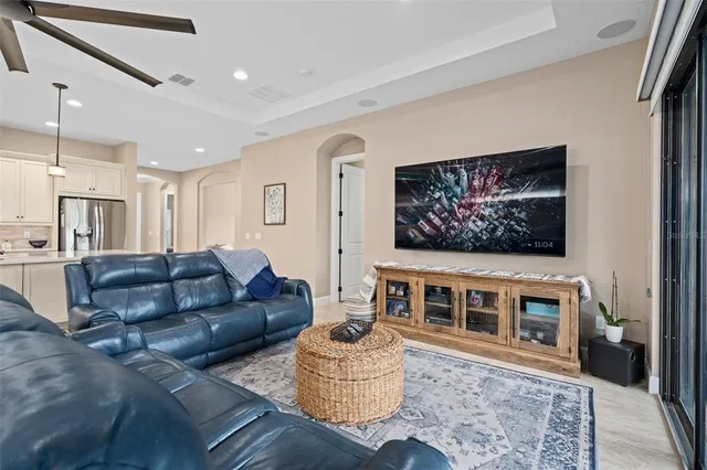 a living room with furniture ceiling fan and a large window