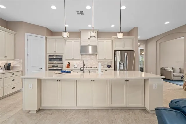 a kitchen with white cabinets and appliances