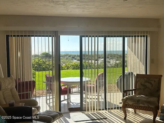 a view of a living room with furniture and floor to ceiling window