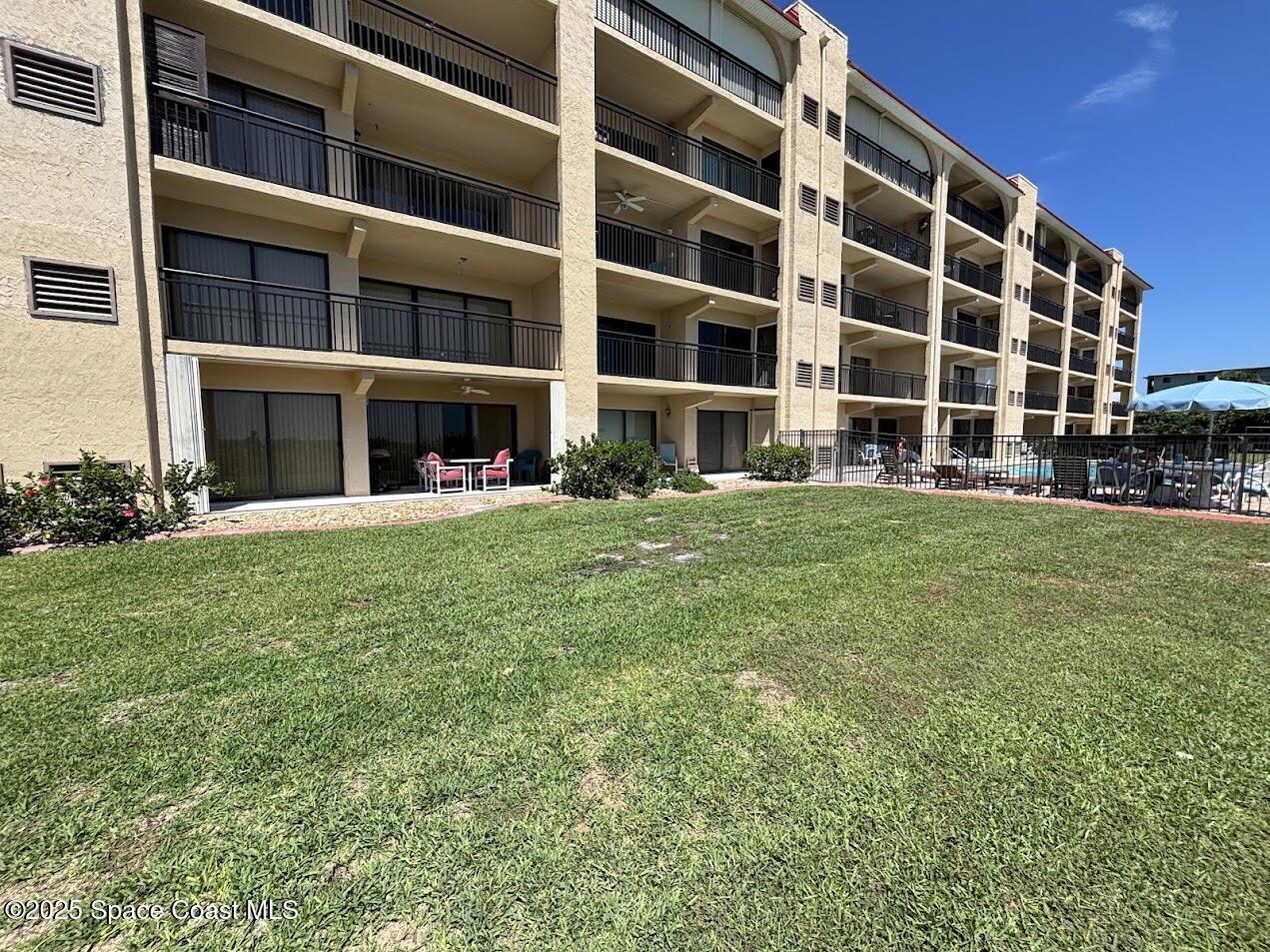 1305 South Atlantic Avenue, Unit 120 Cocoa Beach, FL 32931 - Photo 7 of 10 a view of building with yard