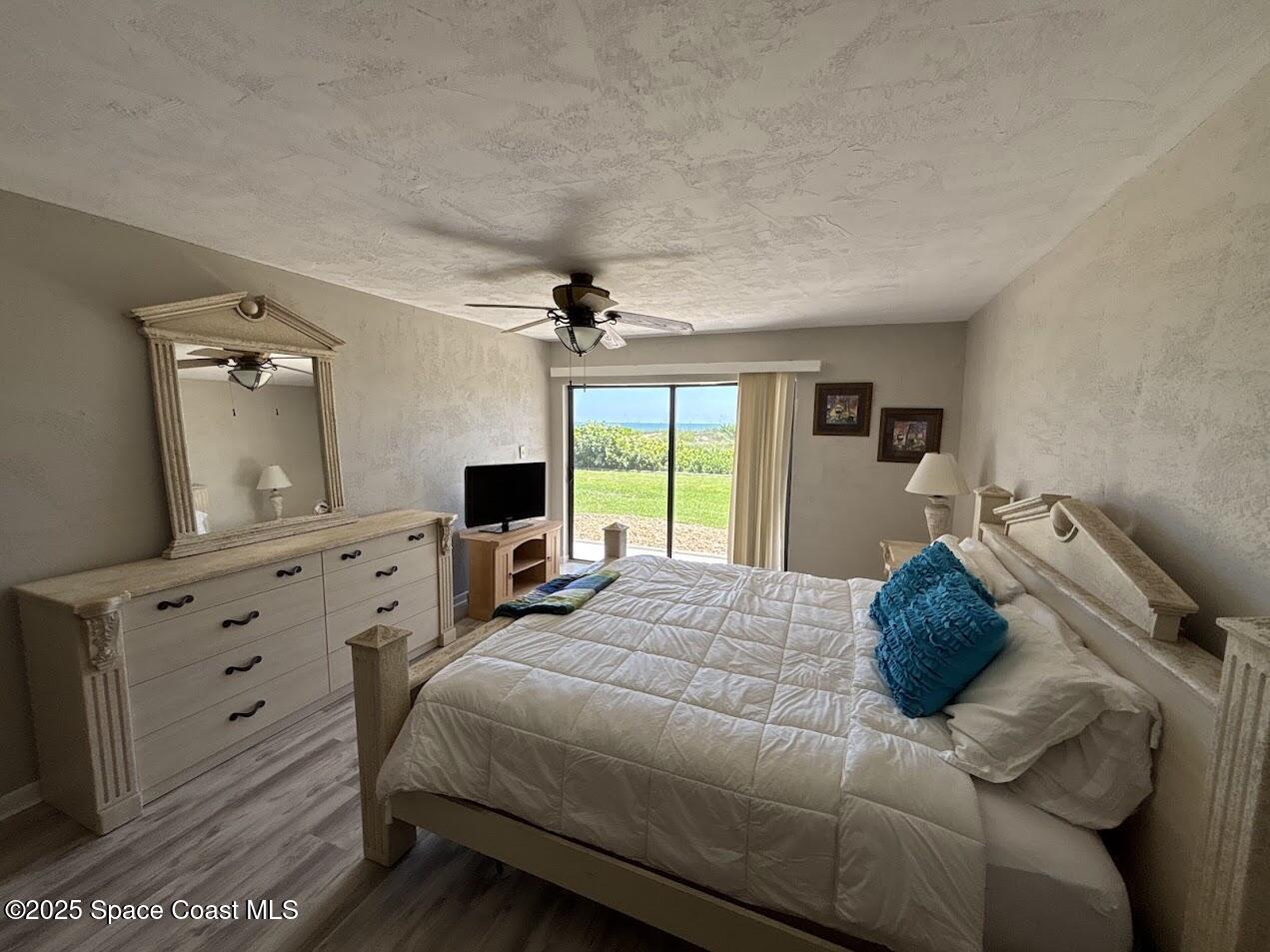 1305 South Atlantic Avenue, Unit 120 Cocoa Beach, FL 32931 - Photo 8 of 10 a bedroom with a bed and a dresser