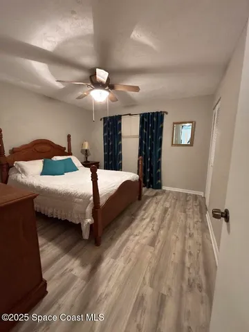 a bedroom with a bed and a ceiling fan