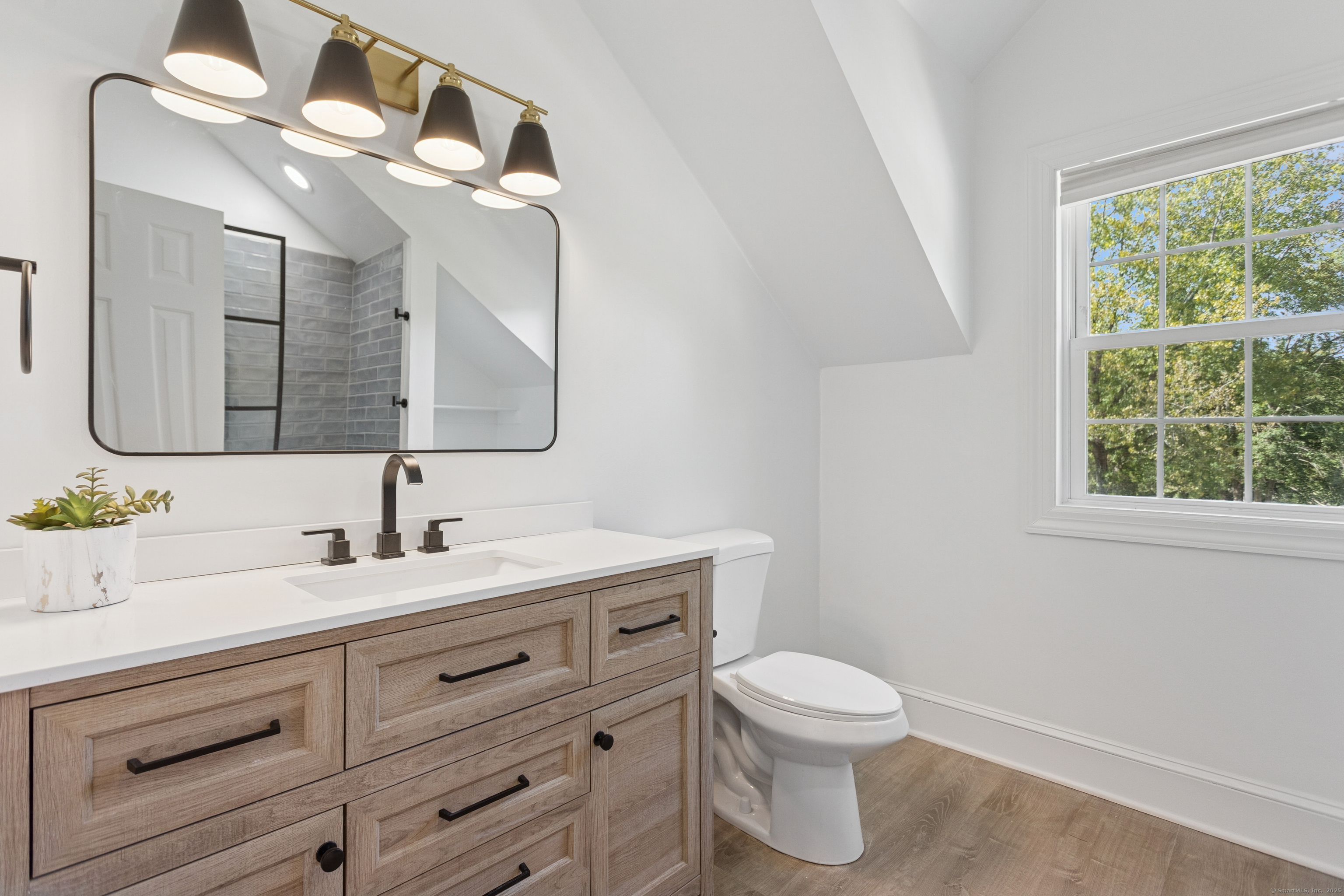 61 Edgewater Commons Lane Westport, CT 06880 - Photo 30 of 37 a bathroom with a toilet a sink a mirror and a window