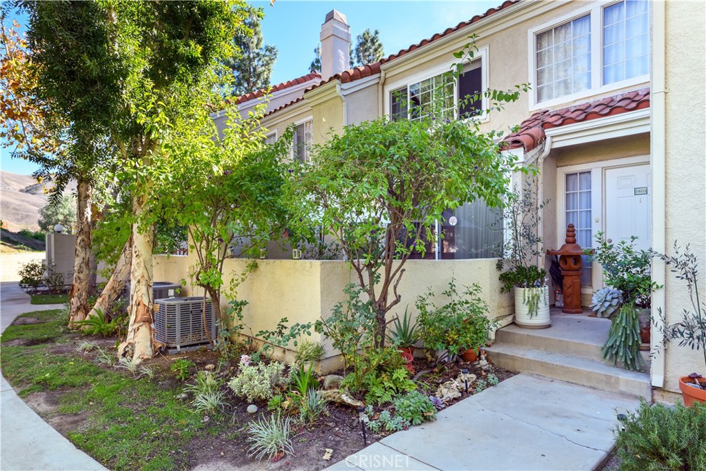 4240 Lost Hills Road, Unit 2403 Calabasas, CA 91301 - Photo 1 of 1 a view of a house with brick walls plants and large tree