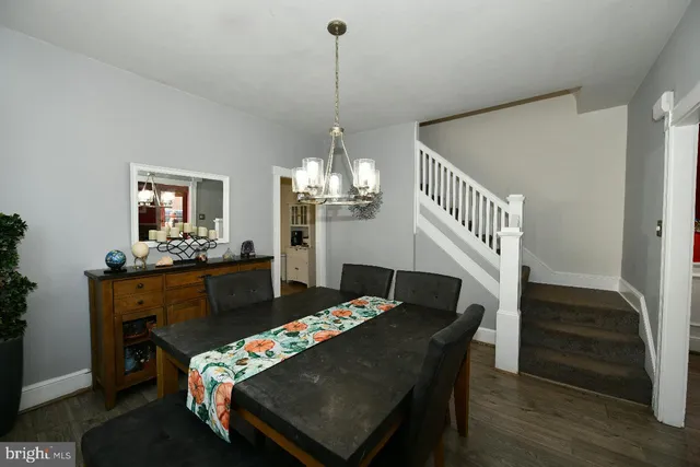 a living room with furniture a dining table and a chandelier