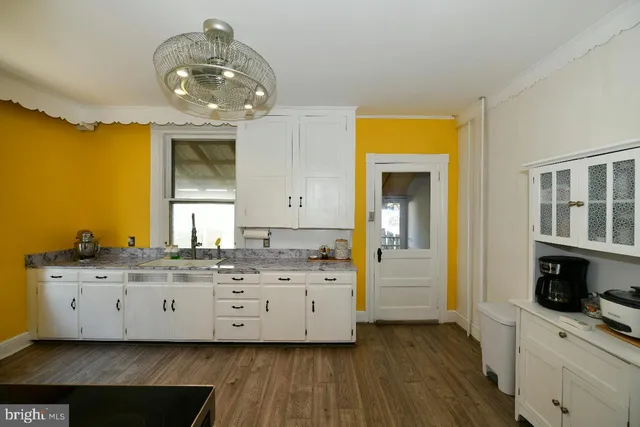 a kitchen with a sink cabinets and wooden floor