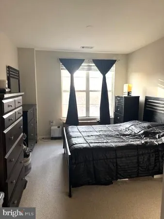 a bedroom with a bed and a flat tv screen on dresser