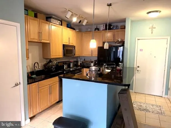 a kitchen with stainless steel appliances granite countertop a sink and a refrigerator