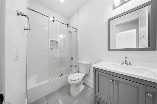 a bathroom with a sink a toilet and a large mirror