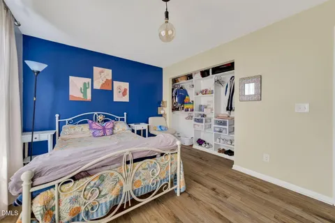 a bedroom with a bed and wooden floor