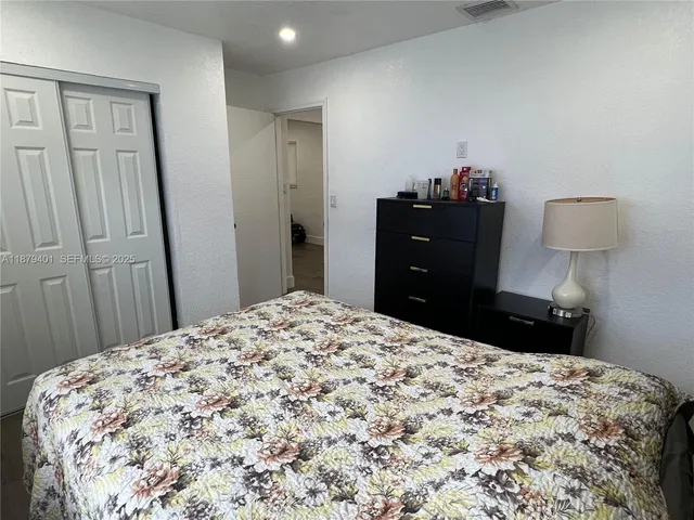 a bedroom with a bed and mirror