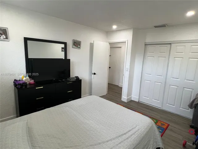 a bedroom with a bed and a flat screen tv