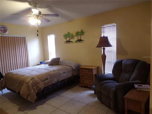 a bedroom with a bed couch and a chandelier