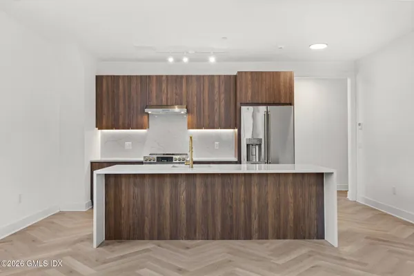 a kitchen with a sink a refrigerator and wooden cabinets