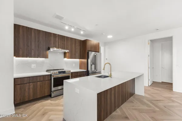 a kitchen with kitchen island a sink stove and refrigerator